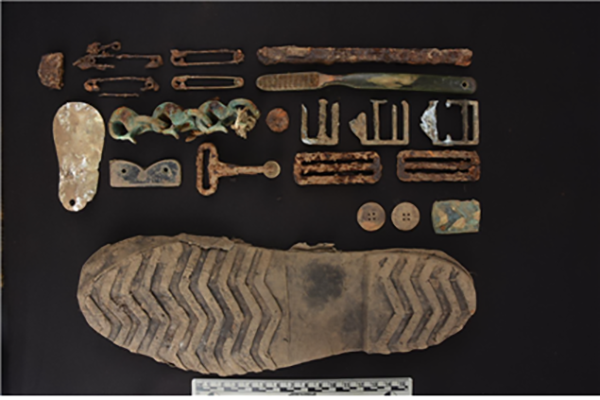 발굴 현장에서 발견된 전사자의 유류품들. 칫솔, 옷핀, 개인 장비용 금속 버클, 전투화 밑창 등이 발굴되었다.