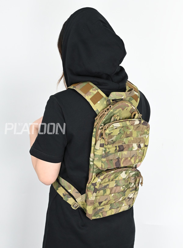  [T3 Gear] 100oz 리로드 하이드레이션 백팩 [멀티캠]. 여성이 메어도 그리 크지 않은 모습에서 컴팩트한 사이즈가 짐작된다.