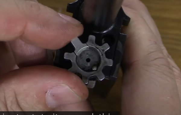 노리쇠 위치를 바꾼 모습. 잘 보면 노리쇠의 갈퀴와 차개 방향이 반대로 돌아간 것을 알 수 있다. AUG의 경우 아예 다른 노리쇠로 교체해야 한다. 동영상 캡쳐.