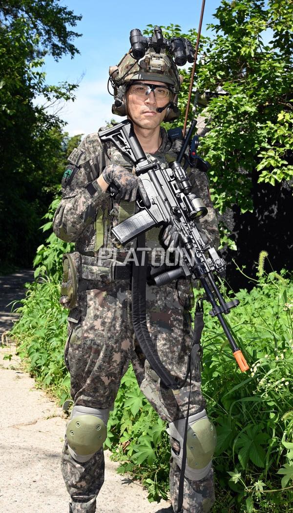 K2C1을 재현한 모형을 휴대하고 있는 김찬우 기자. 수직손잡이와 방열 덮개를 모두 장착하고 있다. 