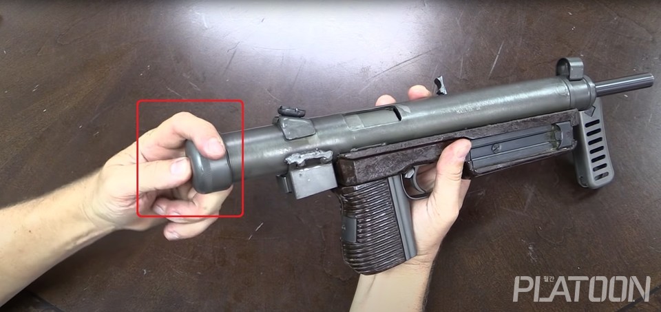 분해를 위해서는 총기 후면의 버튼을 누른 후 세 바퀴 정도 돌려주면 노리쇠뭉치를 탈거할 수 있다. (Forgotten Weapons 영상 갈무리)