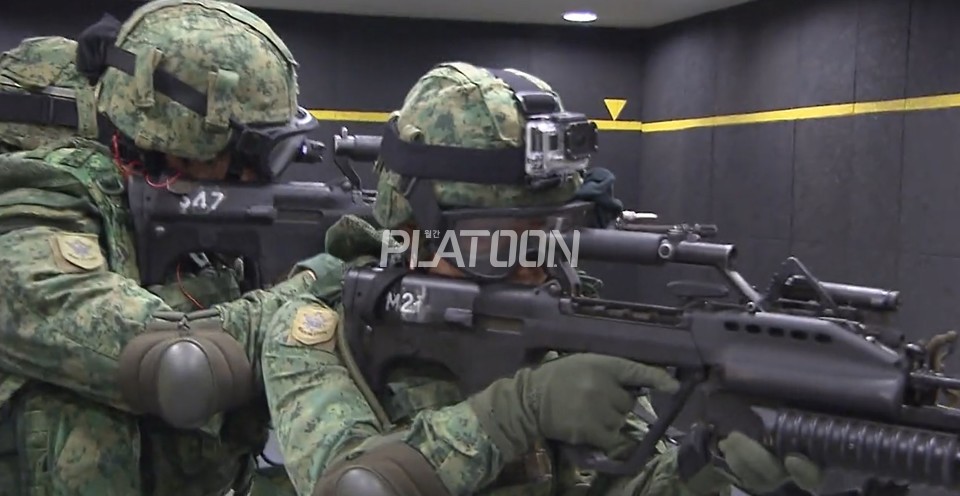 싱가포르 육군의 종합전술훈련장, MMRC(Multi Mission Range Complex)에서 CQB 훈련 중인 싱가포르 육군 병사들. 이게 벌써 9년 전 사진인데 장병들의 피복이나 군장 등이 2022년 현재의 우리 군 장병들에 비해 훨씬 앞서 있다는 걸 알 수 있다. 살짝 부러운 부분. 오른쪽 병사가 휴대하고 있는 건 M203 유탄발사기를 결합한 형태인데, 총열덮개 오른 편에 AN/PEQ-2 타입의 표적지시기를 장착할 수 있는 마운트를 확인할 수 있다. 총열덮개 일체형 표적지시기의 불량 사고가 증가한 이후부터 싱가포르 육군에서는 저런 형태의 마운트를 장착한 SAR-21을 많이 볼 수 있게 되었으나, 현지에서는 체결감이 그리 좋은 물건은 아니라는 평이 대부분이다. 