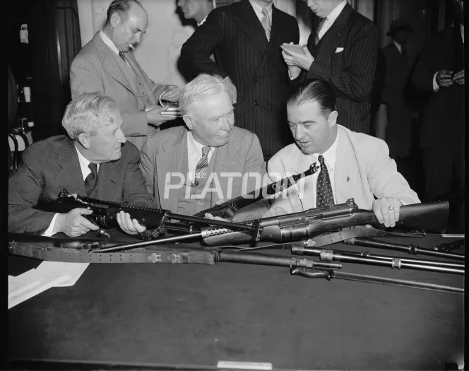 1938년에 미 의회 청문회에서 모리스 셰퍼드 상원 군사위원회 위원장, 조지 A. 린치 미국 보병사령관, 켄터키주 에이브 챈들러 상원의원이 존슨 반자동 소총을 검사하고 있는 모습입니다. 1938년의 청문회에서 멜빈 존슨은 자신의 소총이 M1 개런드보다 훨씬 많이, 그리고 훨씬 빠르게 공급될 거라고 증언하지만, 현실화되진 못합니다.